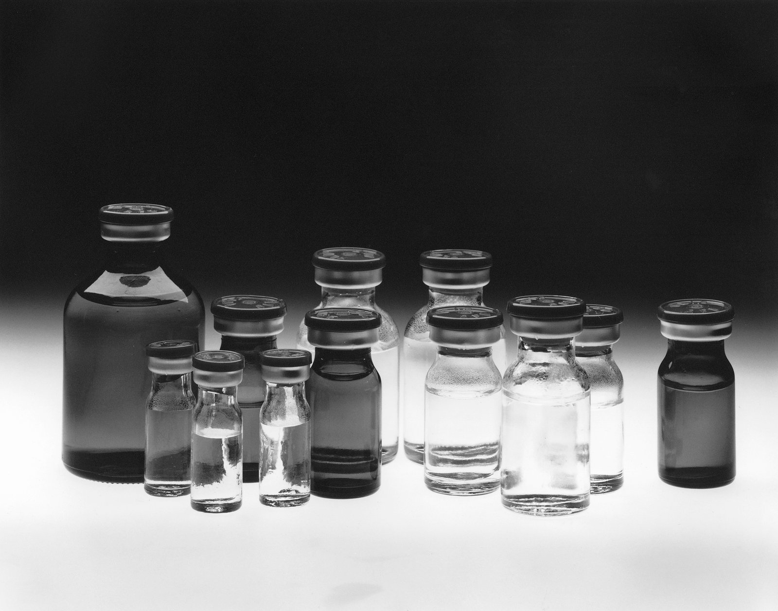 Cancer Drug Prices — छोटी-बड़ी दवा बोतलों और शीशियों का समूह